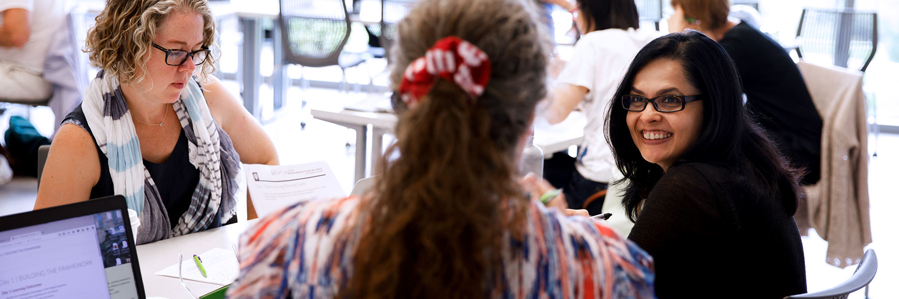 Three people stand at a counter.