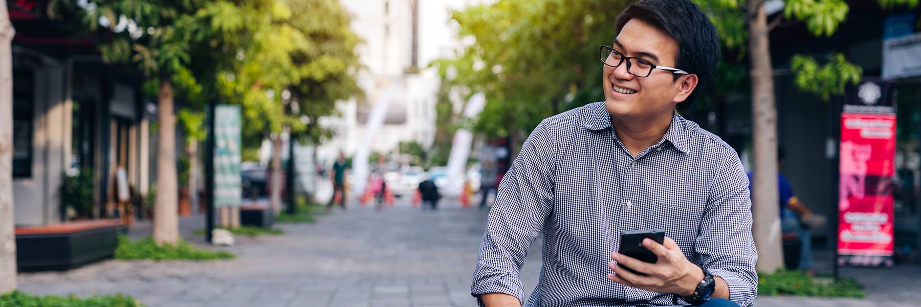 A smiling person holds a mobile phone.